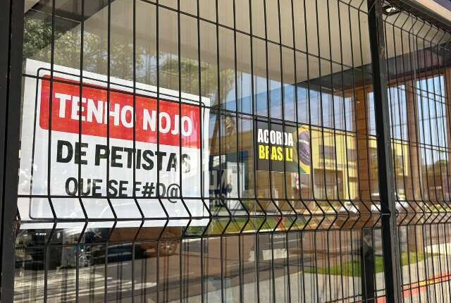 Placa em fachada de loja com recado hostil a petistas divide opiniões em Campo Grande